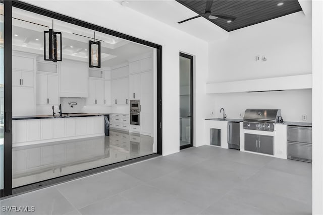 kitchen featuring a ceiling fan, fridge, white cabinetry, pendant lighting, and a sink