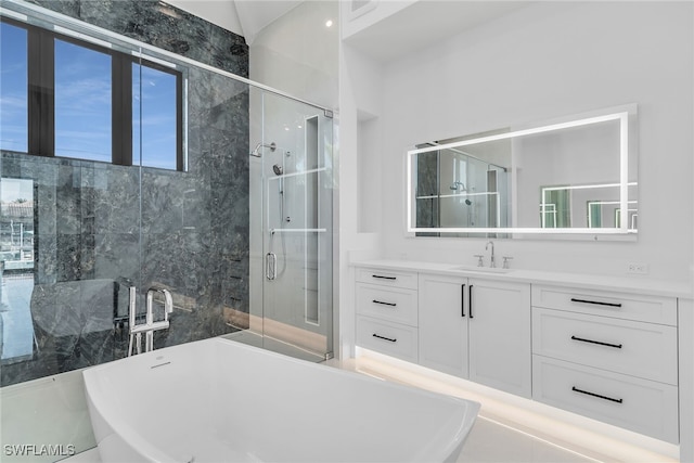 bathroom with a stall shower, a soaking tub, and vanity