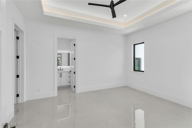 spare room featuring baseboards, ceiling fan, a tray ceiling, a sink, and recessed lighting