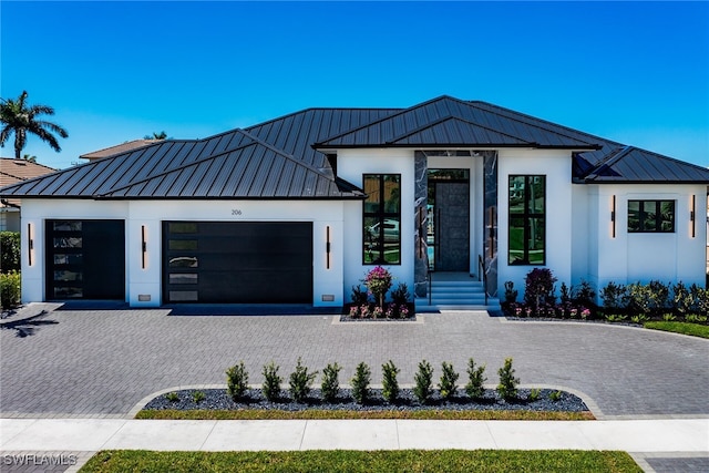 view of front facade featuring decorative driveway, a standing seam roof, and metal roof