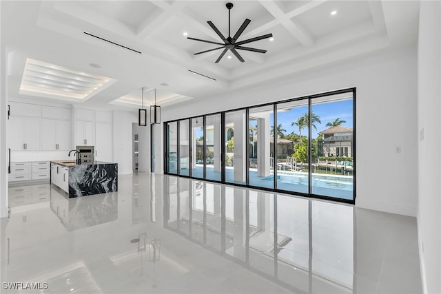 unfurnished room with beamed ceiling, coffered ceiling, a sink, and baseboards