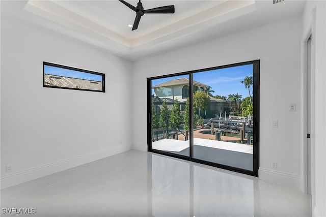 unfurnished room featuring baseboards, a raised ceiling, ceiling fan, concrete flooring, and recessed lighting