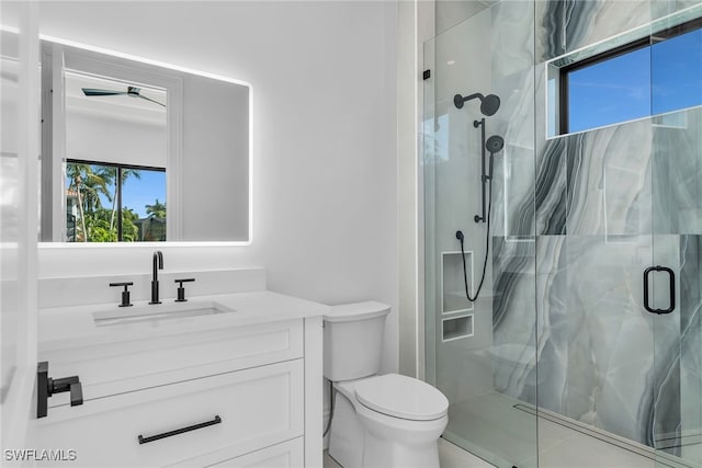 bathroom with toilet, a marble finish shower, and vanity