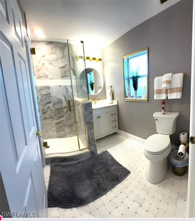 full bath with toilet, a shower stall, vanity, and baseboards