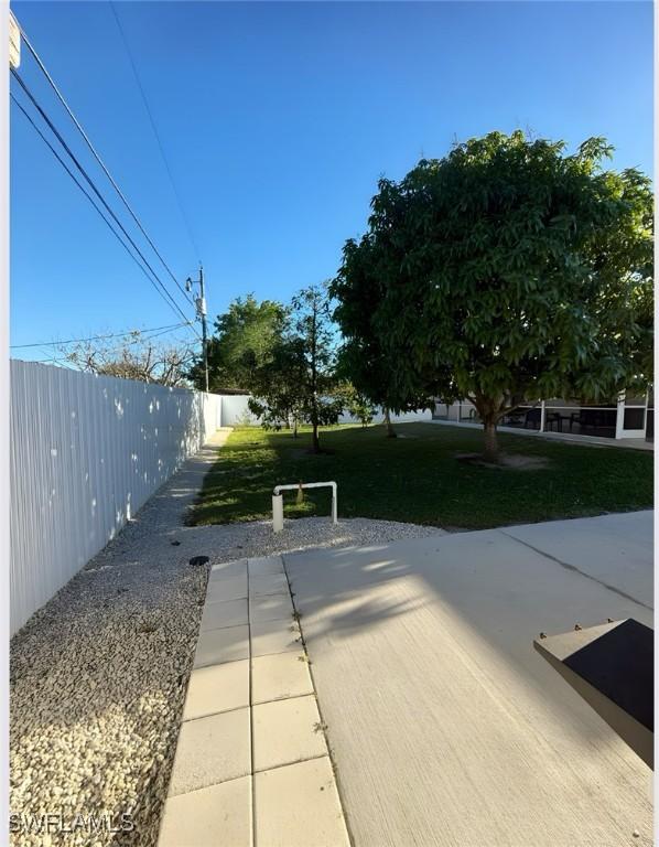 view of home's community with fence and a yard