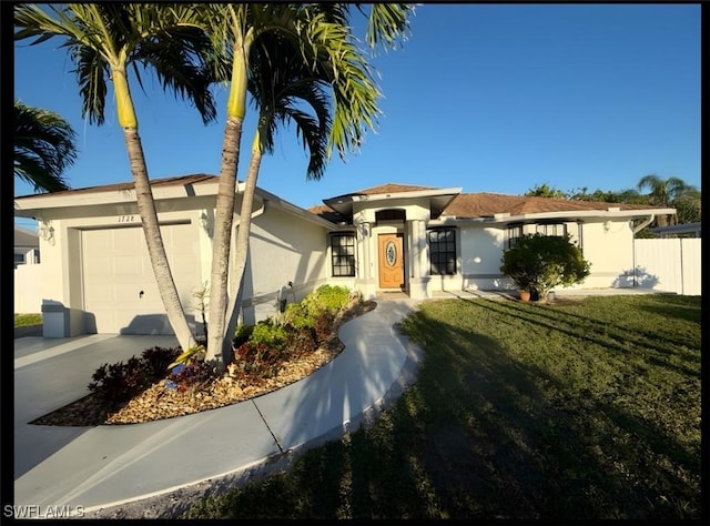 view of front of property featuring a garage, driveway, a front yard, and stucco siding