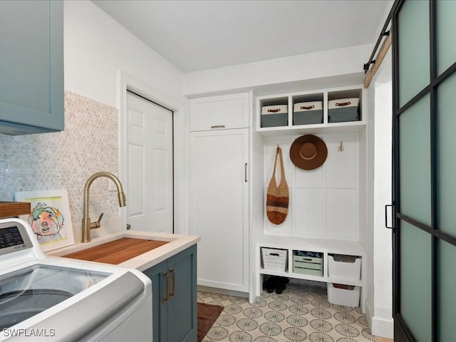 mudroom featuring washer / dryer, a sink, and a barn door