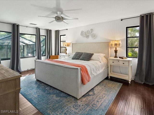 bedroom with a ceiling fan, visible vents, and wood finished floors