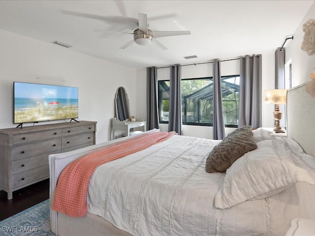 bedroom with dark wood-style flooring, visible vents, and ceiling fan