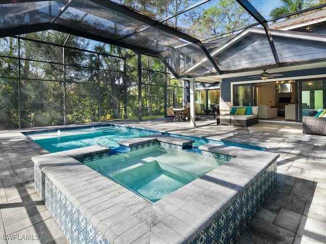 view of pool with a patio, a pool with connected hot tub, a lanai, and an outdoor living space