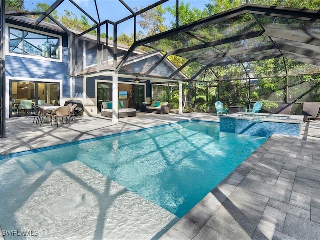 view of swimming pool with a pool with connected hot tub, an outdoor hangout area, a ceiling fan, glass enclosure, and a patio area