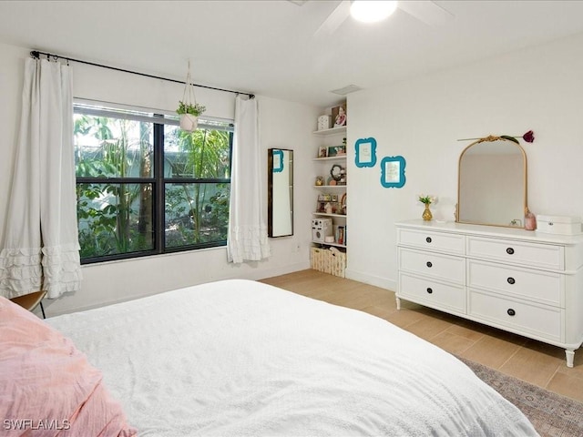 bedroom with baseboards, ceiling fan, and light wood finished floors