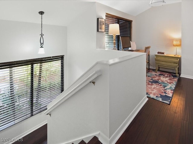 corridor featuring stairway, hardwood / wood-style flooring, and baseboards