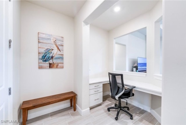 office space with baseboards and built in desk