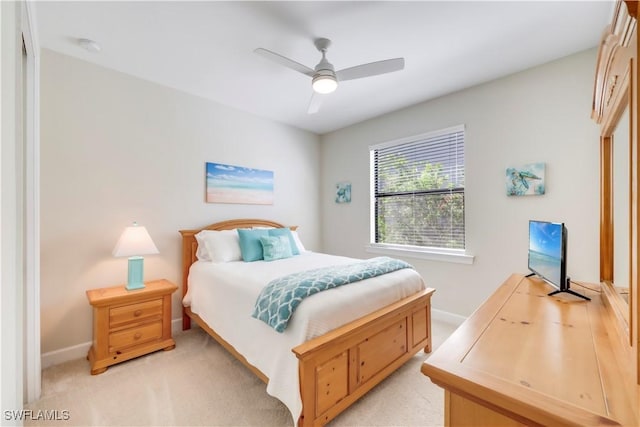 bedroom with baseboards, light colored carpet, and a ceiling fan