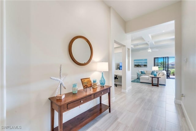 hallway with beamed ceiling, baseboards, and coffered ceiling