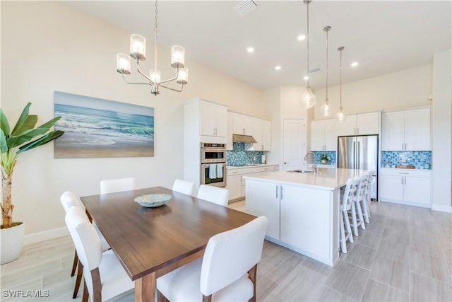 dining area featuring visible vents, baseboards, recessed lighting, a high ceiling, and an inviting chandelier