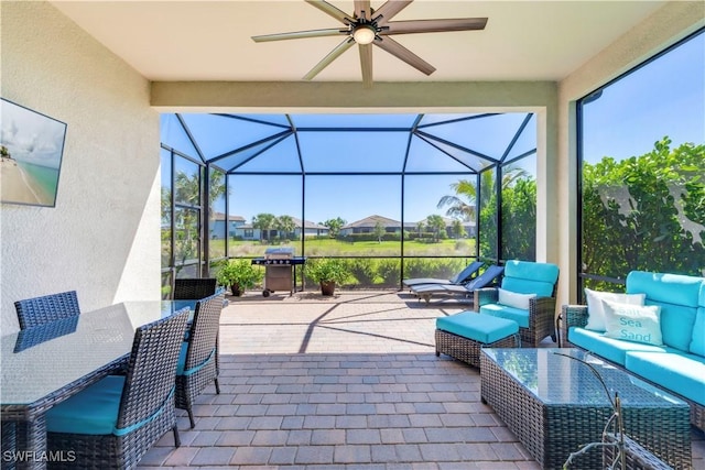 view of patio featuring ceiling fan, a lanai, a grill, and an outdoor hangout area