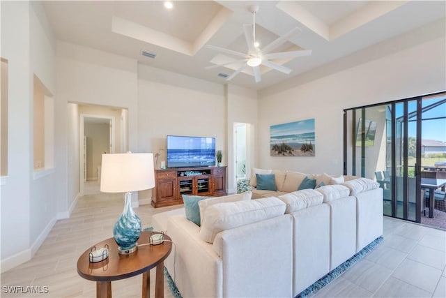 living area with baseboards, visible vents, coffered ceiling, a high ceiling, and beamed ceiling