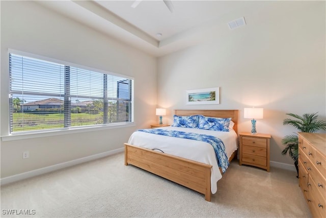 bedroom with visible vents, baseboards, light colored carpet, and ceiling fan