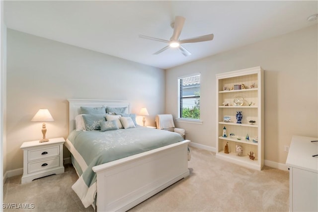 bedroom with a ceiling fan, baseboards, and light carpet