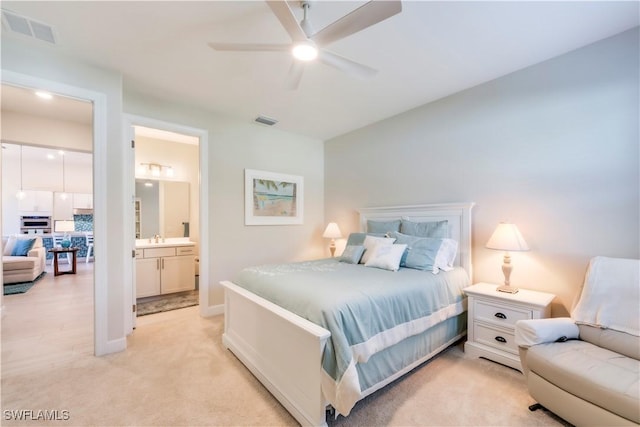 bedroom featuring a sink, visible vents, baseboards, and light colored carpet