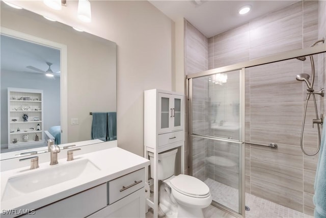 full bathroom with vanity, toilet, a ceiling fan, and a stall shower