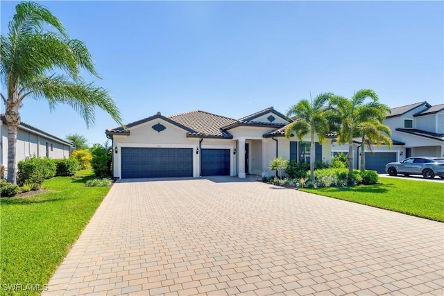 view of front of property featuring decorative driveway, a front lawn, an attached garage, and a tile roof