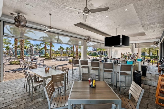 dining space featuring recessed lighting, brick floor, ceiling fan, a textured ceiling, and a raised ceiling