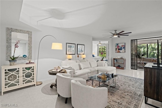 living room with tile patterned flooring, plenty of natural light, baseboards, and a ceiling fan