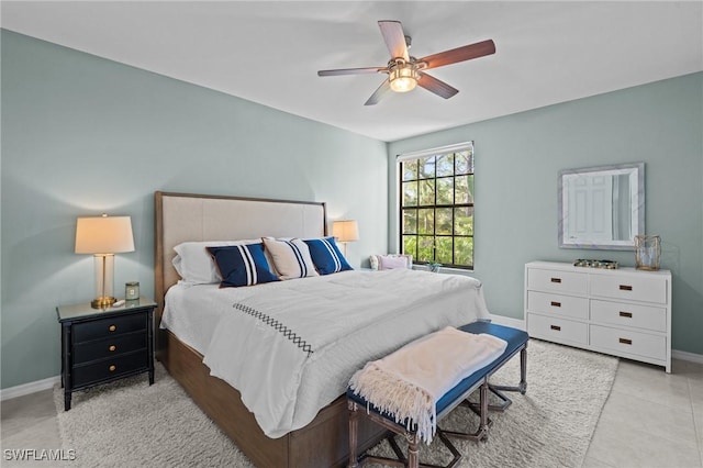 tiled bedroom with baseboards and ceiling fan