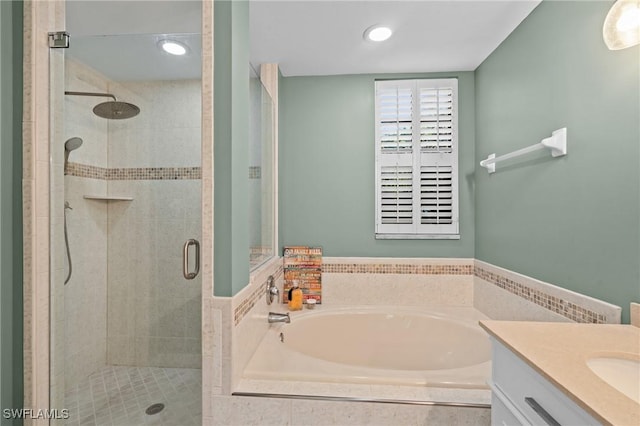 full bathroom featuring a bath, a shower stall, and vanity