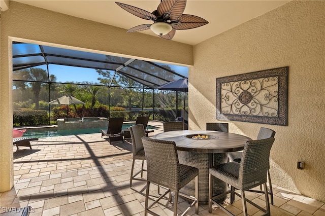 view of patio featuring outdoor dining space, a lanai, a pool with connected hot tub, and ceiling fan