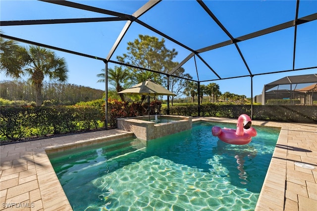 view of swimming pool featuring a lanai, a pool with connected hot tub, and a patio