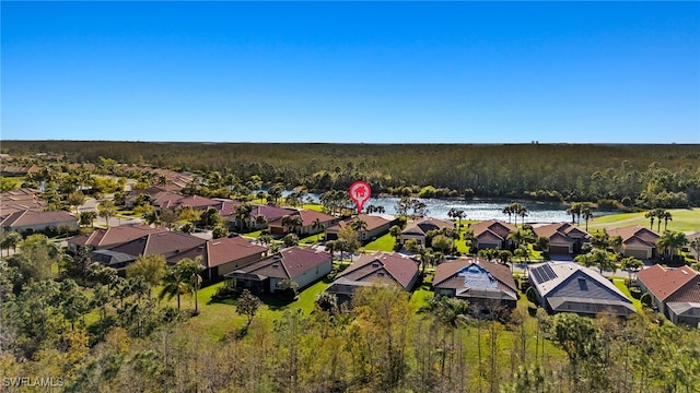 aerial view featuring a wooded view, a residential view, and a water view