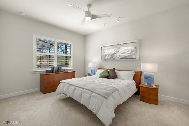 bedroom with light colored carpet, baseboards, and ceiling fan