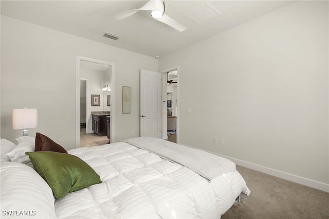 bedroom featuring visible vents, baseboards, ceiling fan, light colored carpet, and ensuite bathroom