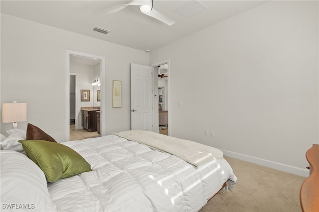 bedroom with visible vents, baseboards, ceiling fan, light colored carpet, and ensuite bath