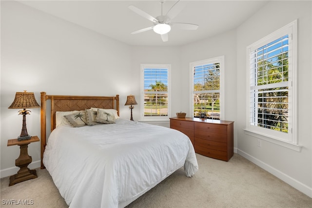 bedroom featuring baseboards, light carpet, and a ceiling fan