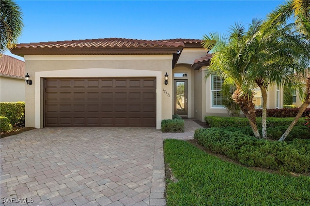 mediterranean / spanish-style home featuring stucco siding, decorative driveway, and a garage