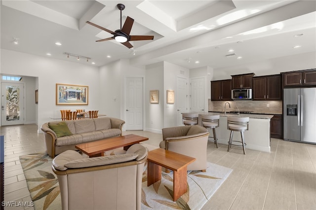 living area with baseboards, coffered ceiling, beam ceiling, recessed lighting, and ceiling fan