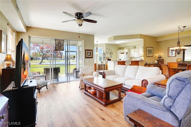 living area featuring a ceiling fan, visible vents, and light wood-style flooring