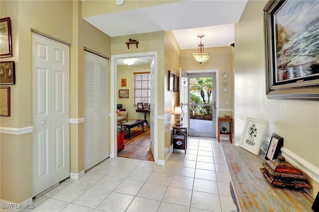 entryway featuring baseboards and light tile patterned floors