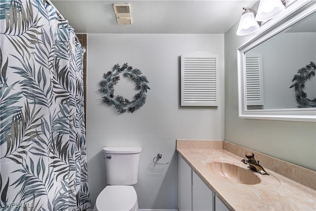 bathroom with a textured ceiling, toilet, vanity, visible vents, and a shower with curtain