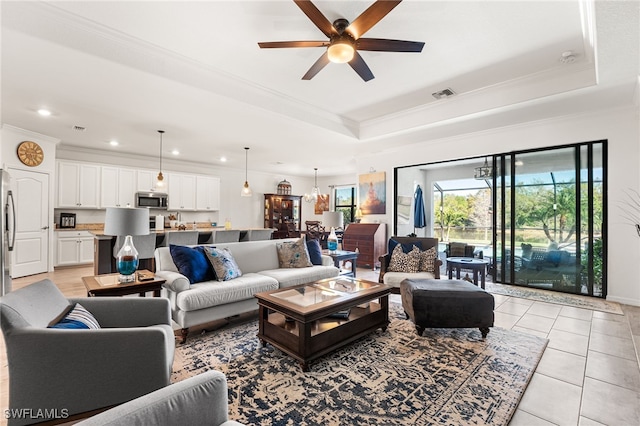 living room featuring a raised ceiling, light tile patterned floors, crown molding, and visible vents