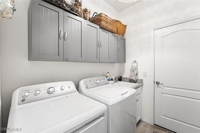 laundry room with cabinet space, washing machine and dryer, and a sink