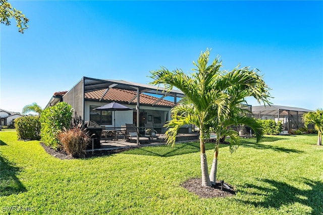 view of yard featuring glass enclosure and a patio