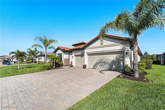 view of front facade with a tiled roof, a front lawn, decorative driveway, and a garage