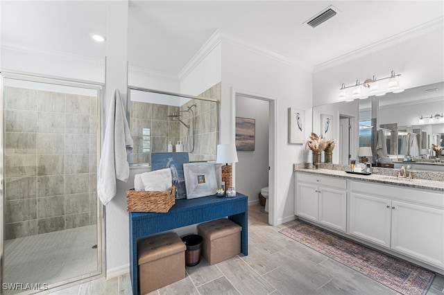 bathroom with visible vents, a stall shower, vanity, and crown molding