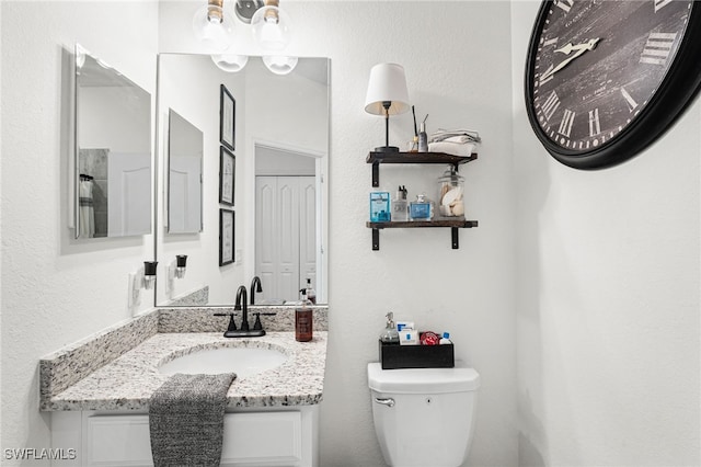 bathroom featuring toilet and vanity